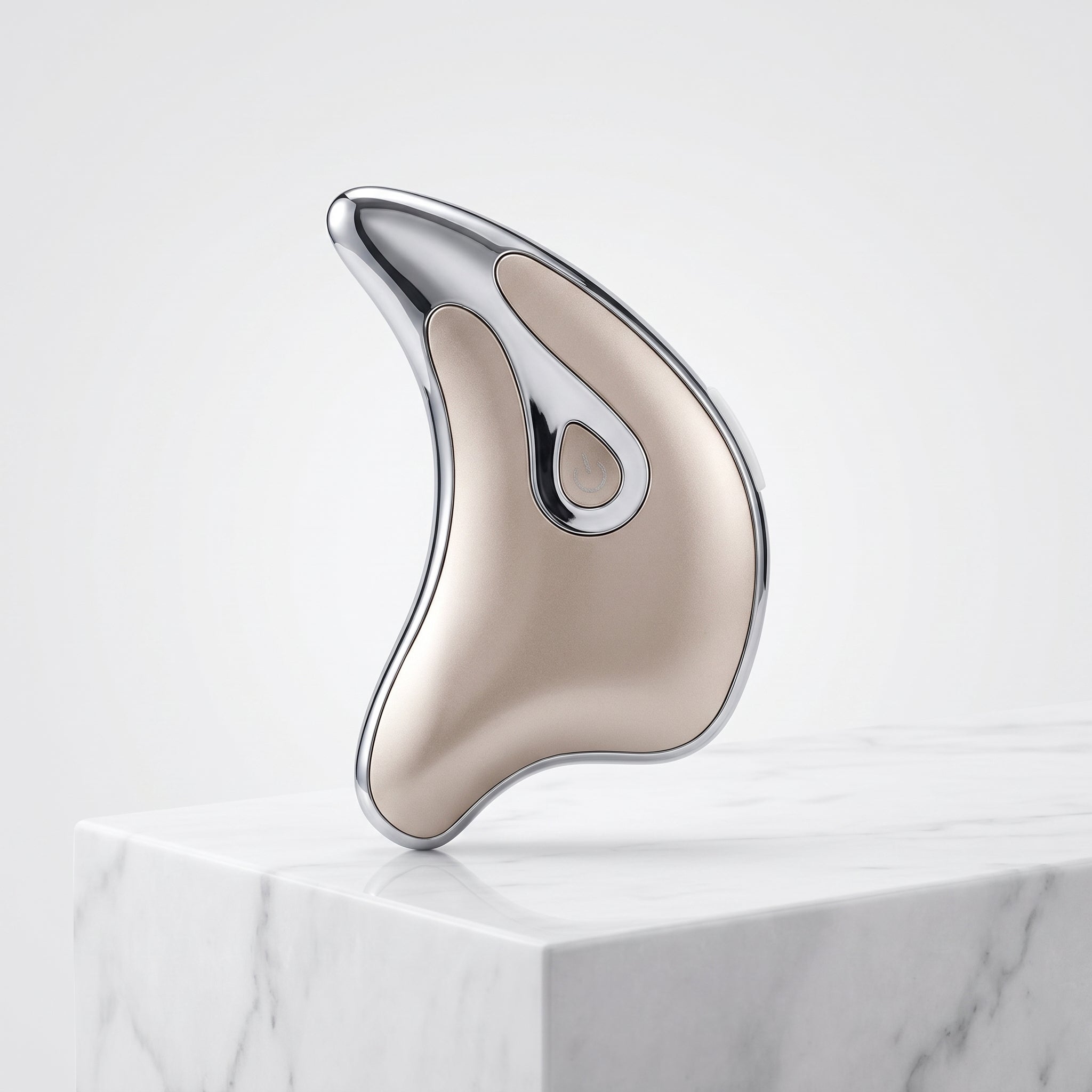 Silver Gua Sha on a marble surface with a white background.